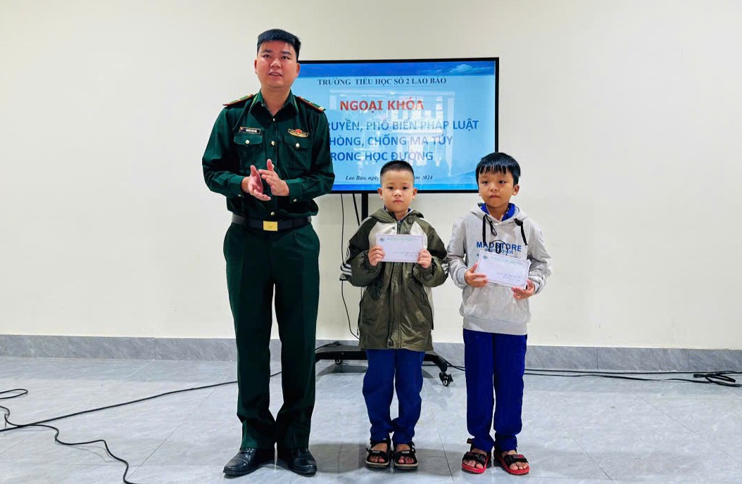Đồng ch&iacute; Thiếu t&aacute; Nguyễn Văn S&aacute;u - Ch&iacute;nh trị vi&ecirc;n ph&oacute; trao qu&agrave; cho 2 em học sinh trong Chương tr&igrave;nh &ldquo;N&acirc;ng bước em đến trường - Con nu&ocirc;i Đồn Bi&ecirc;n ph&ograve;ng&rdquo; - Ảnh: V.S