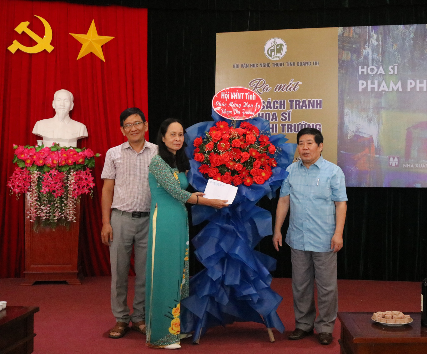 Đồng ch&iacute; Nguyễn Văn D&ugrave;ng, Chủ tịch Hội VHNT tỉnh Quảng Trị tặng hoa cho gia đ&igrave;nh họa sĩ 