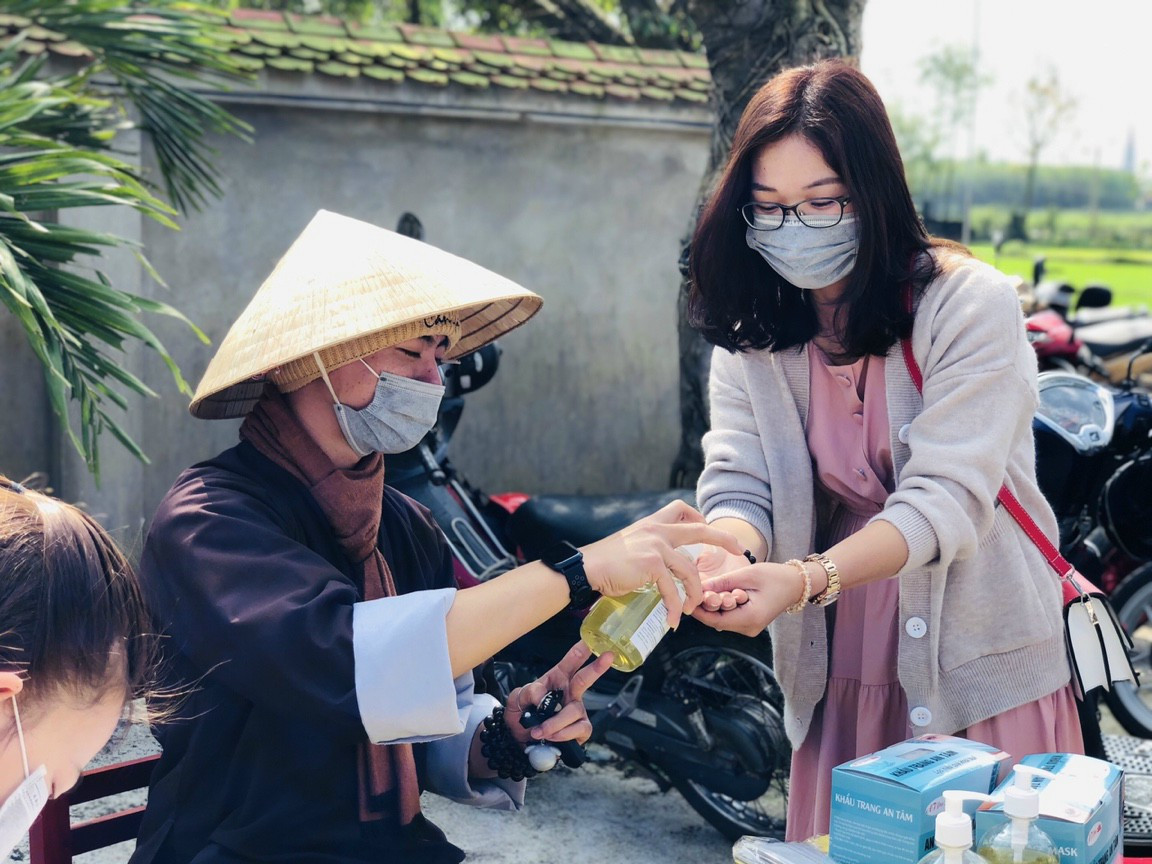 Ch&ugrave;a Trường Kh&aacute;nh (Triệu Phong) thực hiện s&aacute;t khuẩn  v&agrave; ph&aacute;t khẩu trang cho người đi lễ đầu năm - Ảnh: M&atilde;n To&agrave;n
