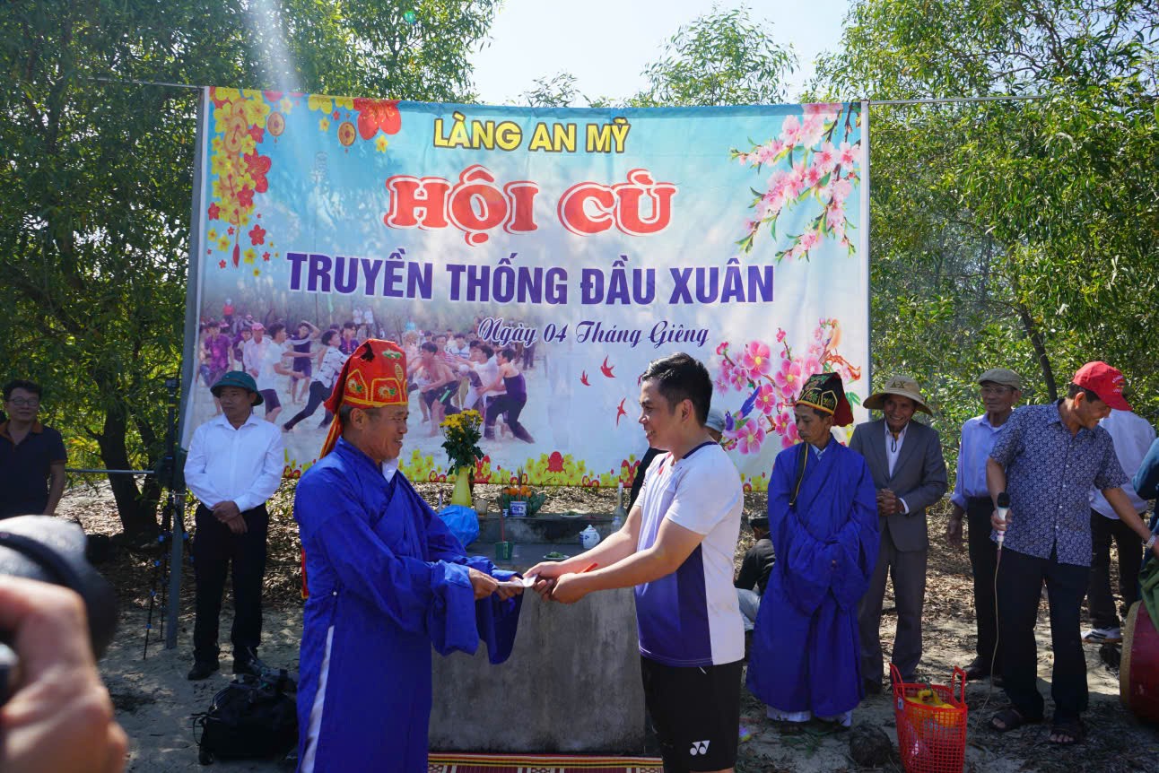 Trưởng l&agrave;ng trao phần thưởng cho người n&eacute;m được c&ugrave; v&agrave;o rọ - Ảnh: C.N
